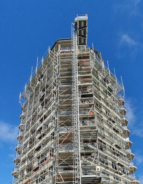 Scaffolded tower with a hoist mast running up the front
